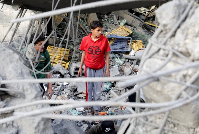 Palestinians inspect the site of an Israeli strike on a house, in Khan Younis in the southern Gaza Strip April 22, 2025. REUTERS/Hatem Khaled