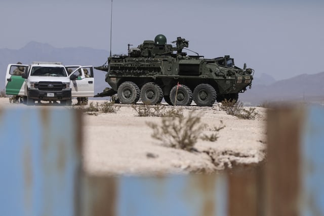 U.S. Border Patrol agents and an eight-wheeled Stryker armored vehicle patrolling the border area in Sunland Park, New Mexico state, U.S., are seen from Ciudad Juarez, Chihuahua state, Mexico on March 28, 2025.