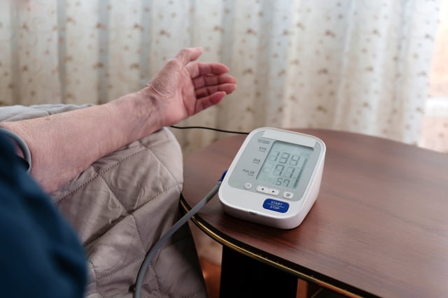 Close-up of a tonometer with digital readings of pulse, heartbeat, blood pressure, medical concept, emphasis on the numbers of the tonometer, the woman's face is not visible.