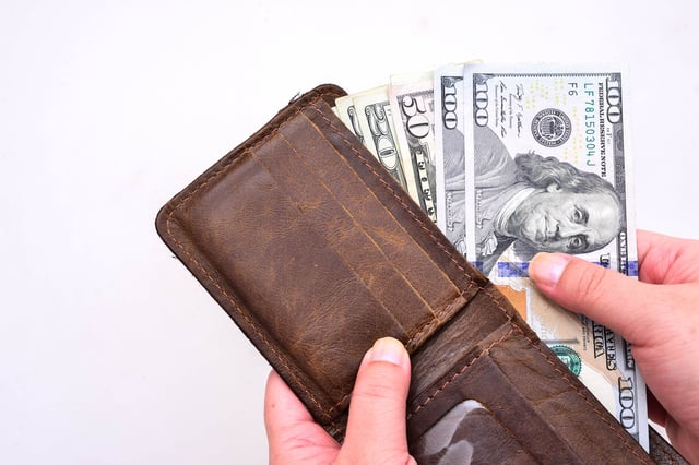 Stock image/file photo: U.S. Dollars in a brown leather wallet.