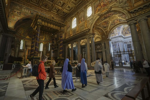 Faithful and nuns walk inside in St. Mary Major basilica, where Pope Francis will be buried, in Rome, Tuesday, April 22, 2025. (AP Photo/Alessandra Tarantino)