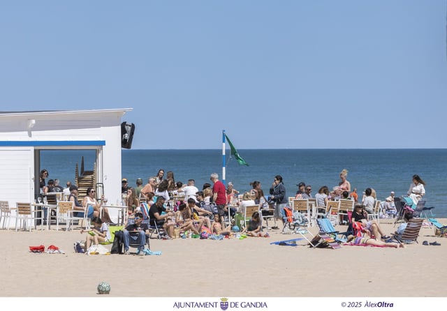 Visitantes de la playa de Gandia, ante un chiringuito, esta Semana Santa.