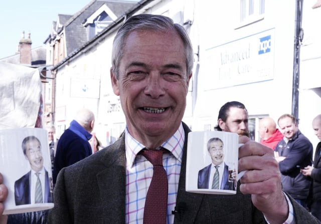 Nigel Farage holding a mug with his picture on it, during his visit to Frodsham, Cheshire (Photo: Peter Byrne/PA Wire)