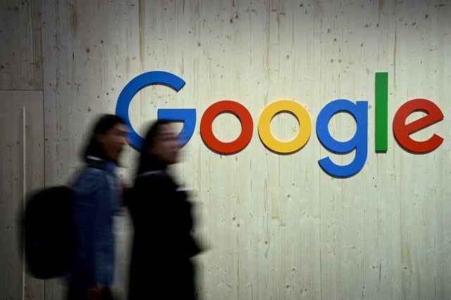 People walk next to a Google logo during a trade fair in Hannover Messe, in Hanover, Germany, April 22, 2024.  REUTERS/Annegret Hilse/File Photo