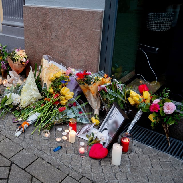 Blumen und Kerzen stehen am Tatort in der Oldenburger Innenstadt