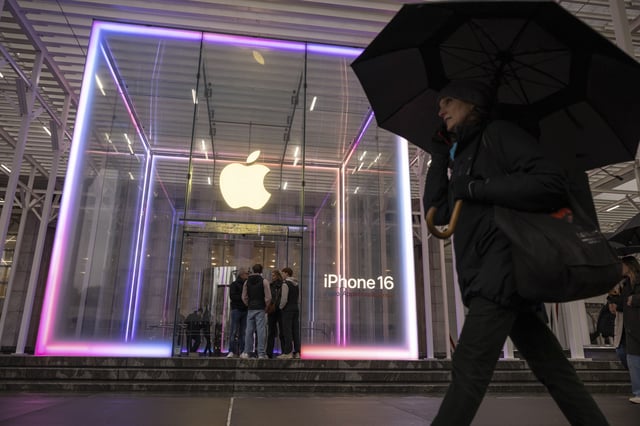A person carrying an umbrella walks past the Apple Store on the 5th Avenue, Monday, April 7, 2025, in New York. (AP Photo/Yuki Iwamura)