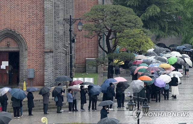 Mourners line up at Myeongdong Cathedral in Seoul to pay their respects to the late Pope Francis on April 22, 2025. (Yonhap)
