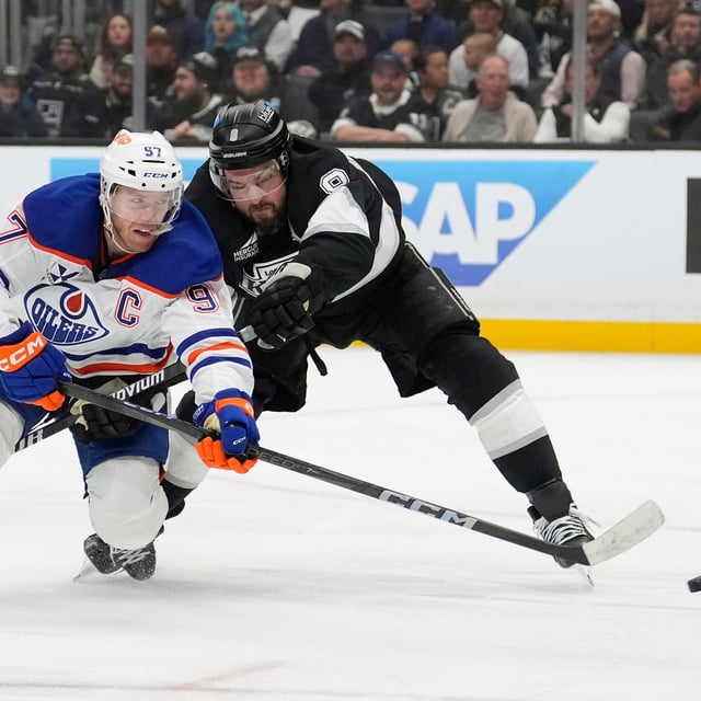 Edmonton Oilers centre Connor McDavidl, left, moves the puck while under pressure from Los Angeles Kings defenceman Drew Doughty during the third period in Game 1 of an NHL hockey first-round playoff series Monday, April 21, 2025, in Los Angeles. (AP Photo/Mark J. Terrill)