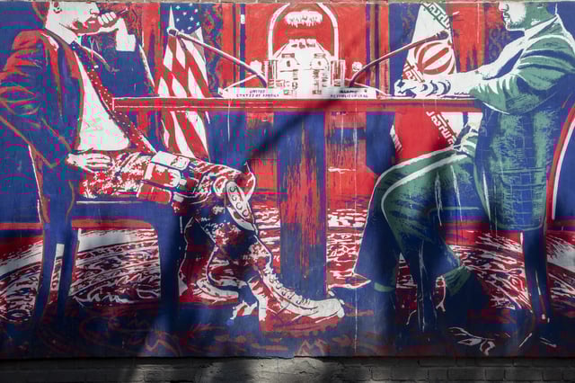 A mural depicting two officials sitting across a table is seen painted on the outer walls of the former U.S. embassy in Tehran on April 19, 2025 in Tehran, Iran. Talks between the United States and Iran over the fate of the Islamic Republic's uranium enrichment program continue at the Omani embassy in Rome. (Photo by Majid Saeedi/Getty Images)