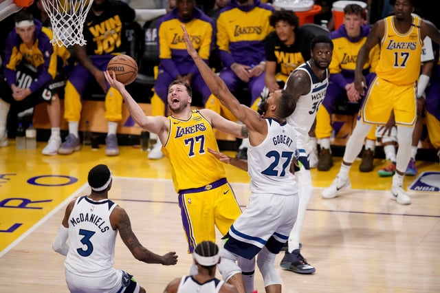 Los Angeles Lakers guard Luka Doncic goes to the basket against Minnesota Timberwolves center Rudy Gobert and forward Jaden McDaniels during the second half of Game 2 of an NBA basketball first-round playoff in Los Angeles, Tuesday, April 22, 2025.