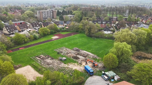 Mitarbeiter der Kampfmittelbergung (KMB) stehen an der Fundstelle vor der Entschärfung einer britischen Fliegerbombe in Kiel-Dietrichsdorf (Aufnahme mit Drohne). 