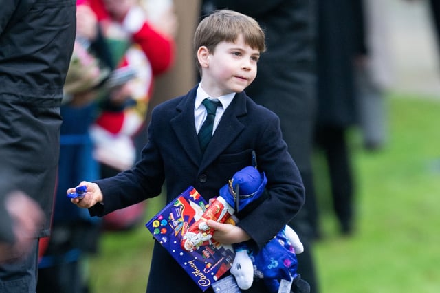Prince Louis with an arm full of chocolates given by royal watchers on the family&#39;s walk home from church in Sandringham on Christmas morning, December 25, 2025.