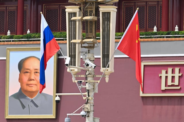 Russia&#39;s national flag (L) by the Chinese flag as a portrait of late Communist leader Mao Zedong outside Tiananmen Gate, during the state visit of Russia&#39;s President Vladimir Putin in Beijing on May 16, 2024.