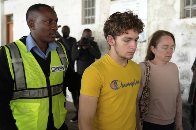 Belgian national Lornoy David, center, who admitted to charges related to the illegal possession and trafficking of live queen ants to sell as exotic pets, walks out of the Jomo Kenyatta International Airport Law Courts in Nairobi, Kenya Wednesday, April 23, 2025. (AP Photo/Brian Inganga)