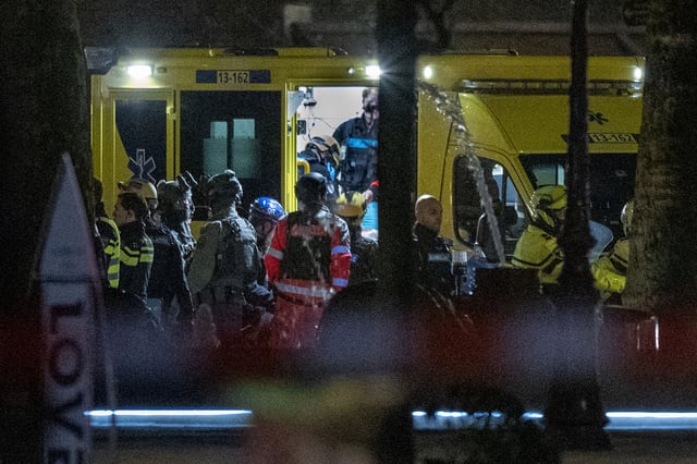 Police special intervention units and rescue workers are seen as the injured hostage taker is carried into an ambulance in Amsterdam, Netherlands, Tuesday, Feb. 22, 2022, where the armed person was holed up in the Apple Store with at least one hostage in an hours-long standoff with scores of police massed outside.