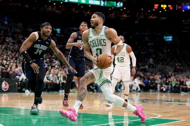 Jayson Tatum #0 of the Boston Celtics drives to the basket against Wendell Carter Jr. #34 of the Orlando Magic in Game One of the Eastern Conference First Round NBA Playoffs at TD Garden.