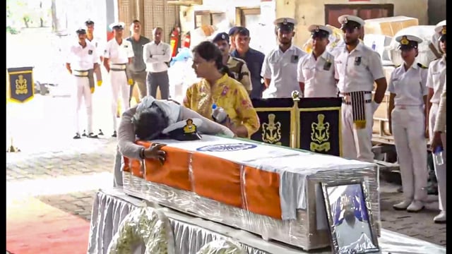 Indian Navy Lt. Vinay Narwal's wife breaks down while paying tribute to her husband after his mortal remains were brought at the cargo terminal of IGI Airport, in New Delhi on Wednesday. (PTI)
