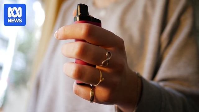 An image of a teenager's hand holding a vape.