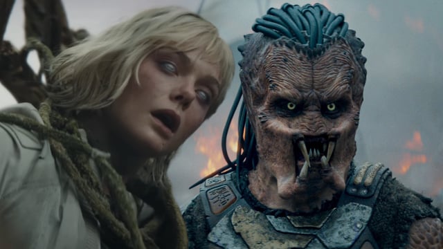 Elle Fanning with a Weyland-Yutani logo on her eyes and the Predator in Predator: Badlands