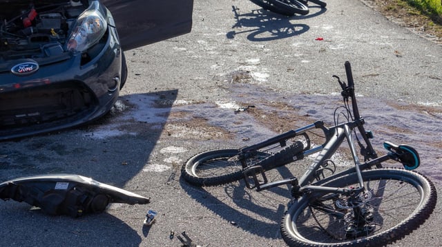 Fahrräder liegen neben einem Auto auf der Straße.
