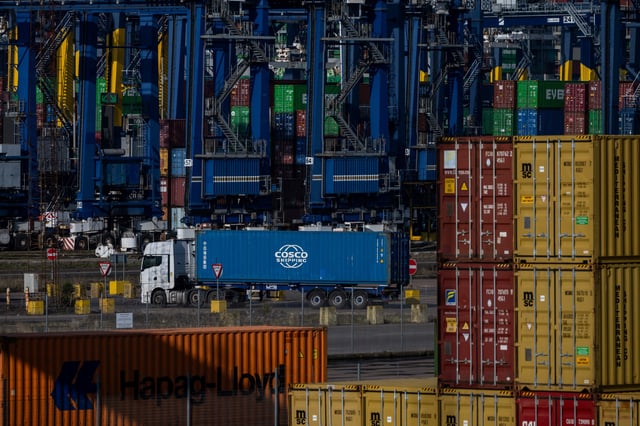 A heavy goods vehicle moves amongst shipping containers at the Port of Felixstowe in Felixstowe, Britain, February 17, 2025. REUTERS/Chris J. Ratcliffe