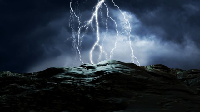 Forked lightning heads earthwards and strikes a darkened landscape