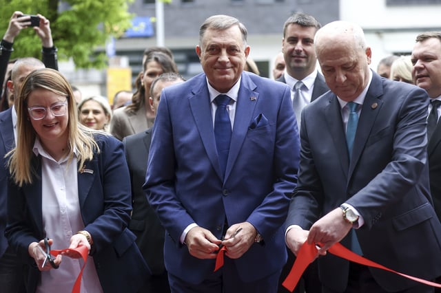 Bosnian Serb President Milorad Dodik, center, cuts the ribbon at the opening ceremony of the rectory building in Istocno Sarajevo, Bosnia, Thursday, April 24, 2025. (AP Photo/Armin Durgut)