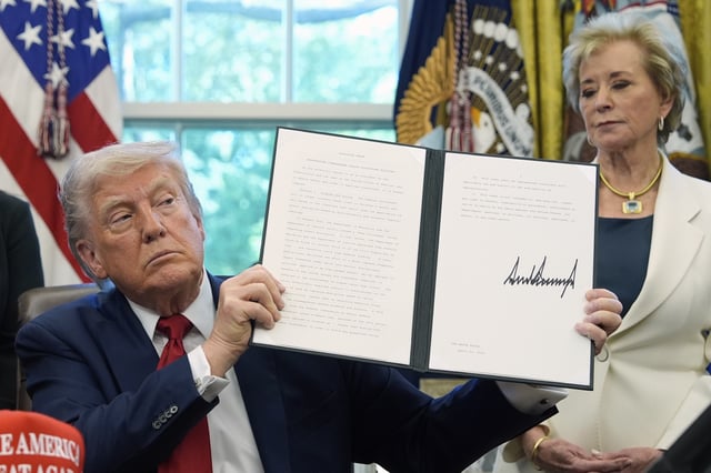 President Donald Trump holds a signed an executive order relating to school discipline policies as Education Secretary Linda McMahon listens in the Oval Office of the White House, Wednesday, April 23, 2025, in Washington. (AP Photo/Alex Brandon)