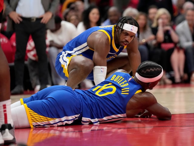 Golden State Warriors guard Buddy Hield checks on forward Jimmy Butler after a collision with Houston Rockets’ Amen Thompson during Game 2 in Houston, Wednesday, April 23, 2025.