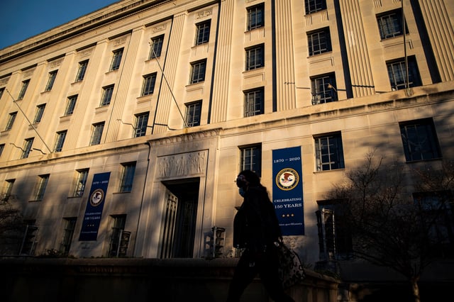 A woman walks past the U.S. Department of Justice Building, in Washington, U.S., December 15, 2020. REUTERS/Al Drago/File Photo