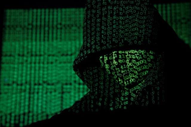 A projection of cyber code on a hooded man is pictured in this illustration picture taken on May 13,  2017. Capitalizing on spying tools believed to have been developed by the U.S. National Security Agency, hackers staged a cyber assault with a self-spreading malware that has infected tens of thousands of computers in nearly 100 countries. REUTERS/Kacper Pempel/Illustration     TPX IMAGES OF THE DAY