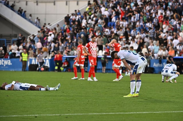 Los jugadores del Leganés, agotados, con los del Girona, al fondo, desolados, al final del encuentro.