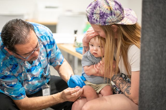 One year-old River Jacobs is held by his mother, Caitlin Fuller, while he receives an MMR vaccine from Raynard Covarrubio, at a vaccine clinic put on by Lubbock Public Health Department on March 1, 2025, in Lubbock, Texas.