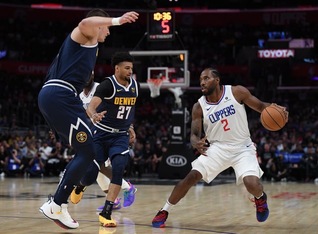 Kawhi Leonard #2 of the LA Clippers steps back on Nikola Jokic #15 and Jamal Murray #27 of the Denver Nuggets during the first half at Staples Center on October 10, 2019 in Los Angeles, California.
