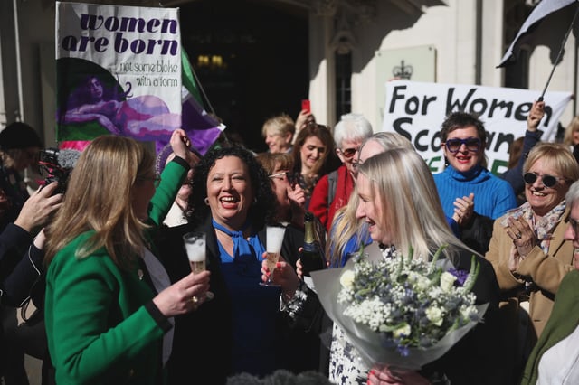 Campaigners outside the UK Supreme Court celebrate the ruling that the legal definition of a woman excludes trans women. (Getty)