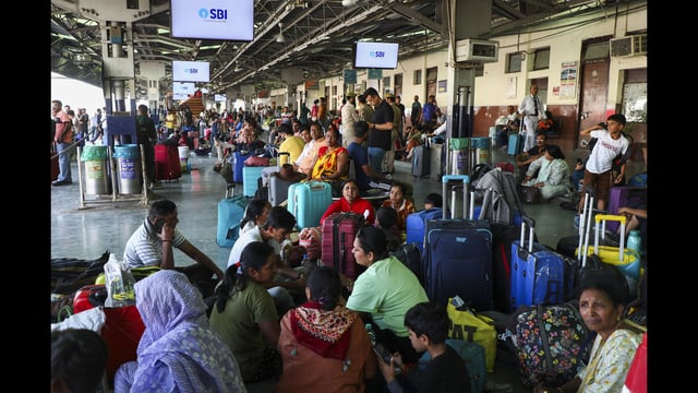 Tourists wait at Jammu railway station after returning from Kashmir on Thursday. (PTI)