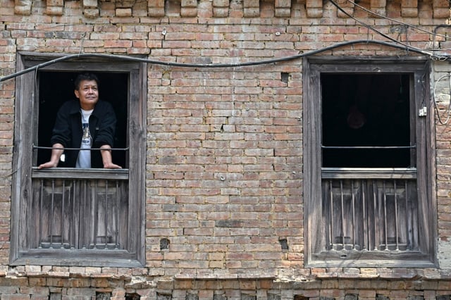 Ram Bahadur Nakarmi, a survivor of the 2015 earthquake, looks out a window at his residence during an interview with AFP