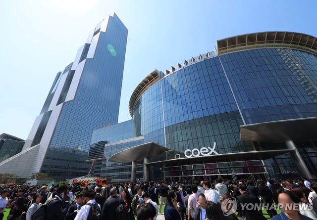 People evacuate from the COEX exhibition center in Seoul on April 25, 2025, after a fire broke out at a restaurant inside the center. (Yonhap)