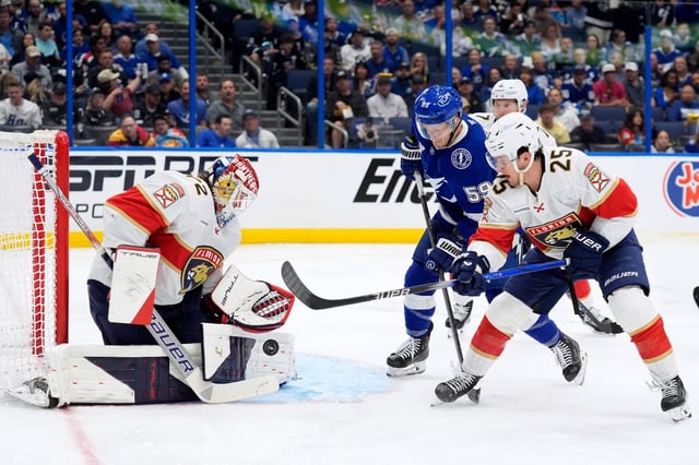 Florida Panthers goaltender Sergei Bobrovsky (72) stops a shot as right wing Mackie Samoskevich (25) keeps Tampa Bay Lightning center Jake Guentzel (59) from a rebound during the second period in Game 2 of an NHL hockey Stanley Cup first-round playoff series, Thursday, April 24, 2025, in Tampa, Fla. (AP Photo/Chris O&#39;Meara)