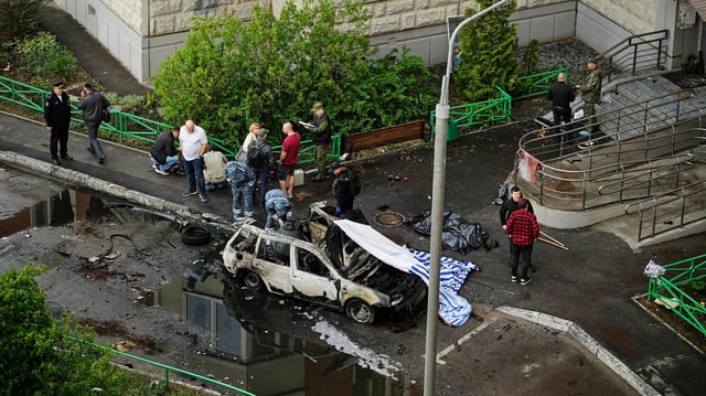 Ermittler untersuchen die Überreste eines Autos, in dem in einem Vorort von Moskau eine Bombe detonierte