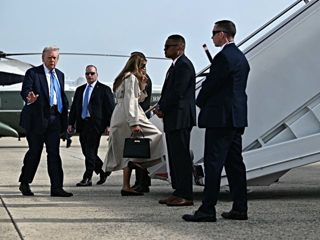 US President Donald Trump and First Lady Melania Trump make their way to board Air Force One before departing from Joint Base Andrews in Maryland on April 25, 2025. Trump is heading to Rome, Italy for the funeral for Pope Francis. The president and first lady are traveling to Rome to attend the funeral of Pope Francis. (Photo by Mandel NGAN / AFP)