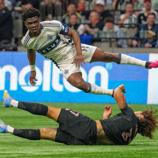 Vancouver Whitecaps' Emmanuel Sabbi (top) jumps over Inter Miami's Maximiliano Falcon during the second half of a CONCACAF Champions Cup semifinal soccer match, in Vancouver, on Thursday, April 24, 2025. THE CANADIAN PRESS/Christopher Morris