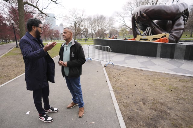 Wayne Lucas, right, who sixty years ago participated at the Freedom Rally on Boston Common, talks with Imari Paris Jeffries, the president and CEO of Embrace Boston, at the "The Embrace" sculpture on the common, Tuesday, April 15, 2025, in Boston. (AP Photo/Charles Krupa)