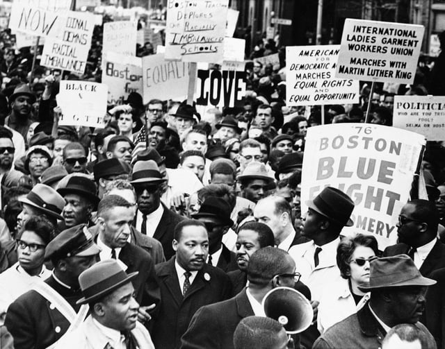 Dr. Martin Luther King Jr., is completely surrounded as he leads a civil rights march in Boston, April 23, 1965, en route to historic Boston Common where he will address a crowd. (AP Photo, file)