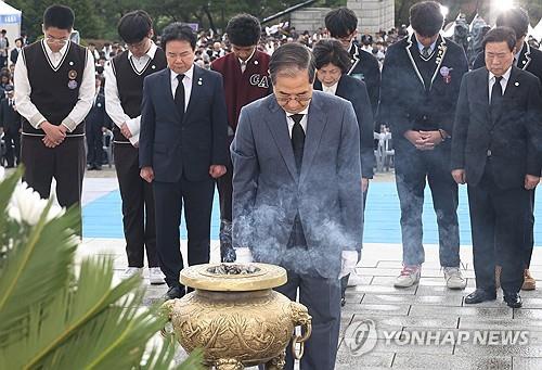 Acting President Han Duck-soo (front) offers a silent prayer to the victims of the 1960 pro-democracy civil uprising at the April 19th National Cemetery in Seoul on April 19, 2025. (Yonhap)