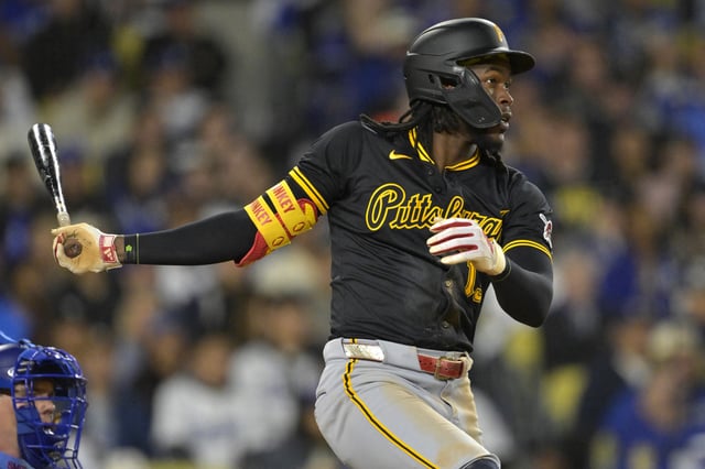 Apr 25, 2025; Los Angeles, California, USA;  Pittsburgh Pirates center fielder Oneil Cruz (15) hits a RBI single in the fifth inning against the Los Angeles Dodgers at Dodger Stadium. Mandatory Credit: Jayne Kamin-Oncea-Imagn Images