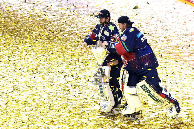 Jake Hildebrand (l) und Jonas Stettmer tragen den Pokal gemeinsam zu den Fans.