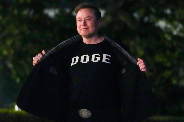Elon Musk shows off a shirt that says "DOGE" as he walks on the South Lawn of the white House after stepping off Marine One upon arrival to the White House in Washington, DC on March 9.