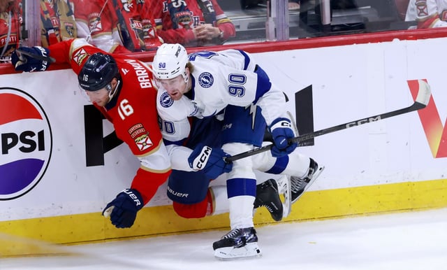 Tampa Bay Lightning defenseman J.J. Moser (90) checks Florida Panthers center Aleksander Barkov (16) into the boards during the first period in Game 3 of an NHL hockey Stanley Cup first-round playoff series, Saturday, April 26, 2025, in Sunrise, Fla. (AP Photo/Rhona Wise)