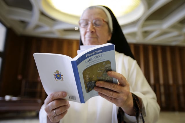 A nun reads Pope Francis' new encyclical titled 'Laudato si' at the Vatican June 18, 2015.